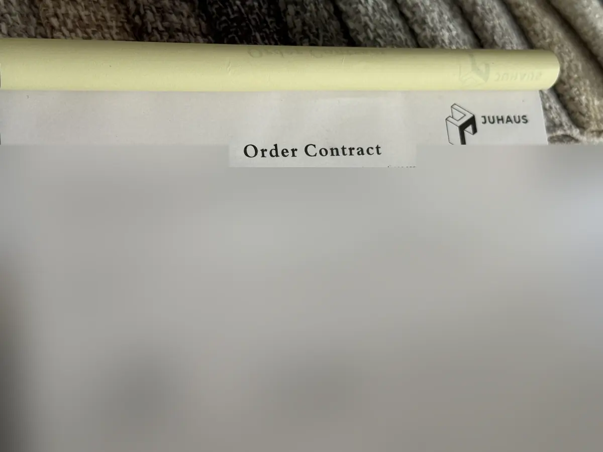Title and Juhaus logo on a photographed order-contract form, with all filled details obscured
