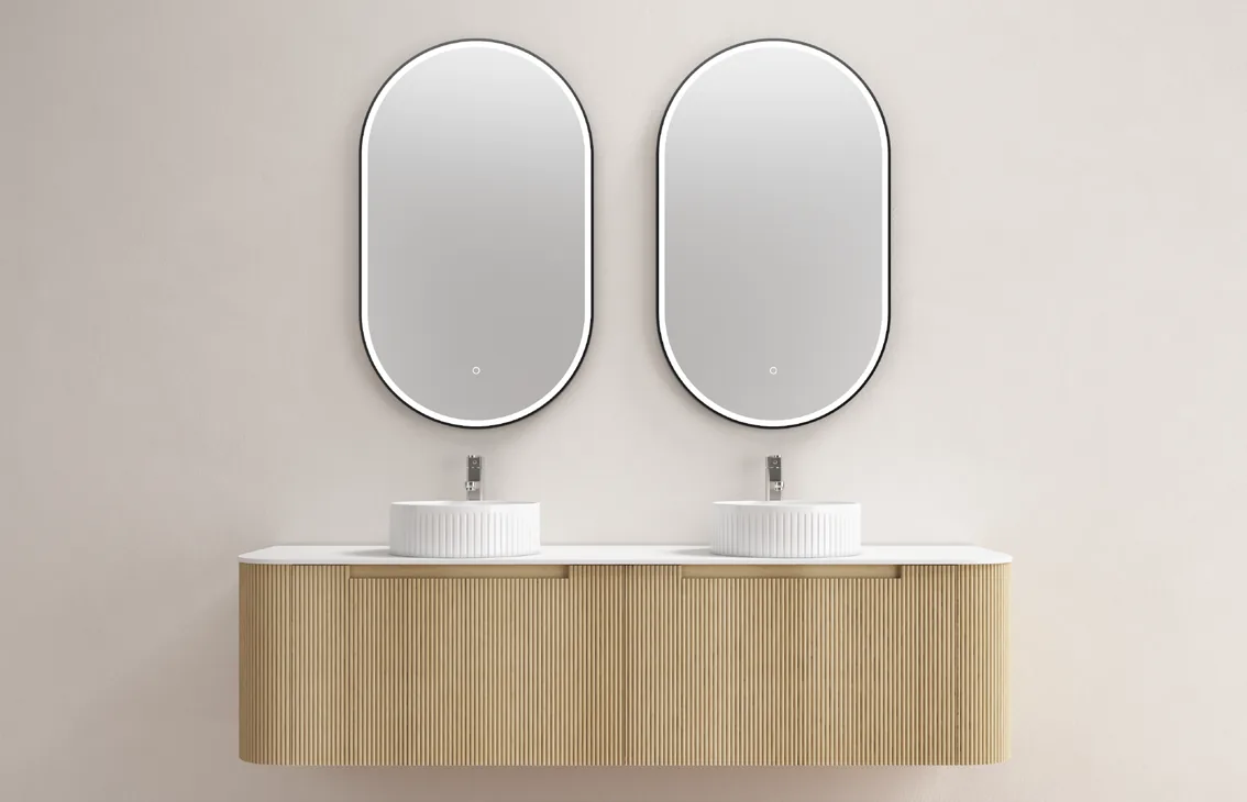A wall-hung fluted vanity with two basins and two rounded mirrors.