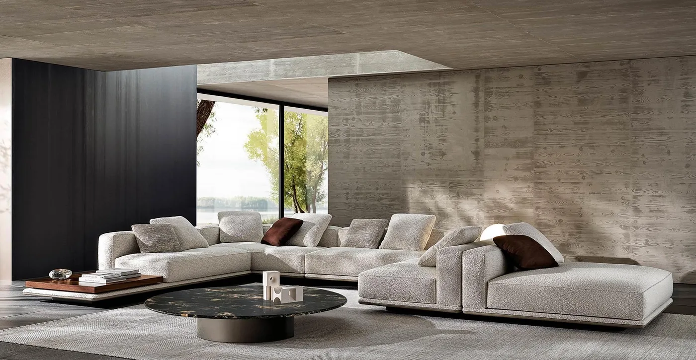 A grey modular sofa arrangement with broad cushions and a low table in a timber-lined living space.