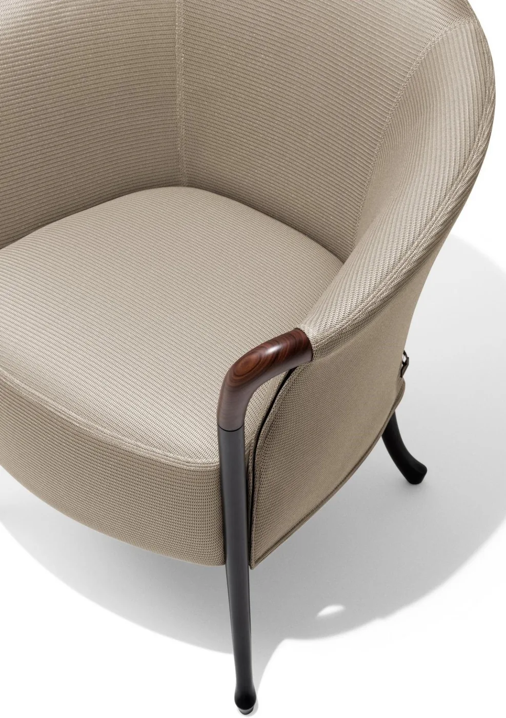A curved light-coloured lounge chair with slender dark legs and timber-coloured arm details.