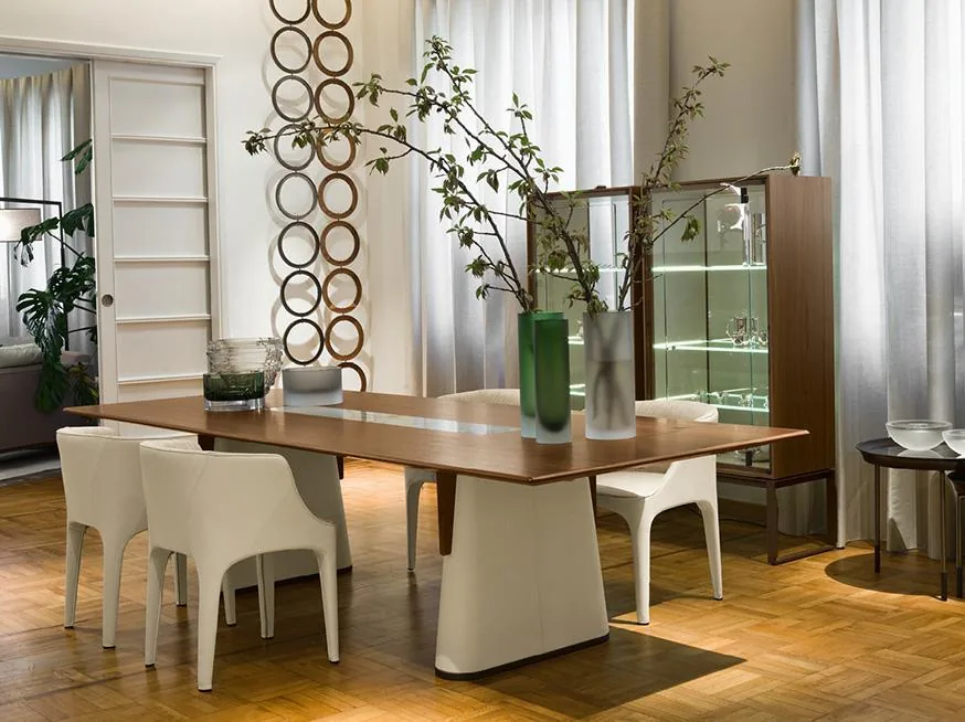 A rectangular timber-coloured tabletop on pale supports with light dining chairs.