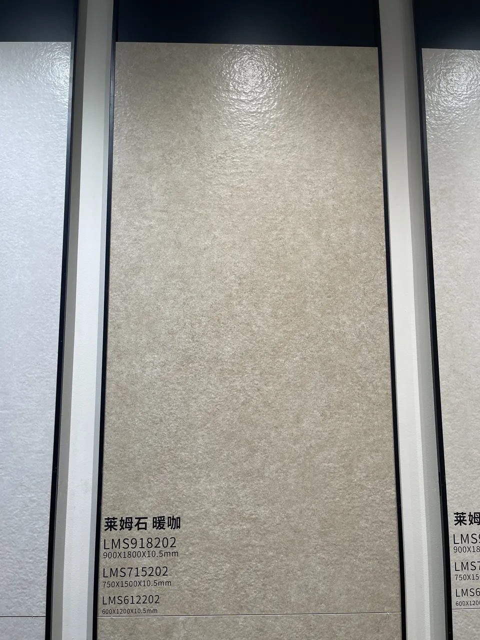 Close view of a warm grey limestone-look sample board with printed reference codes.