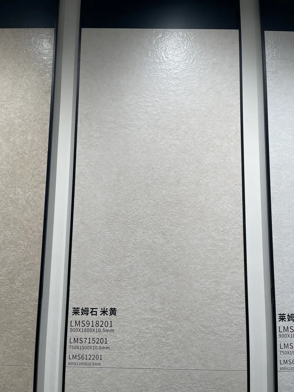 Close view of a pale limestone-look display board with a fine textured surface.