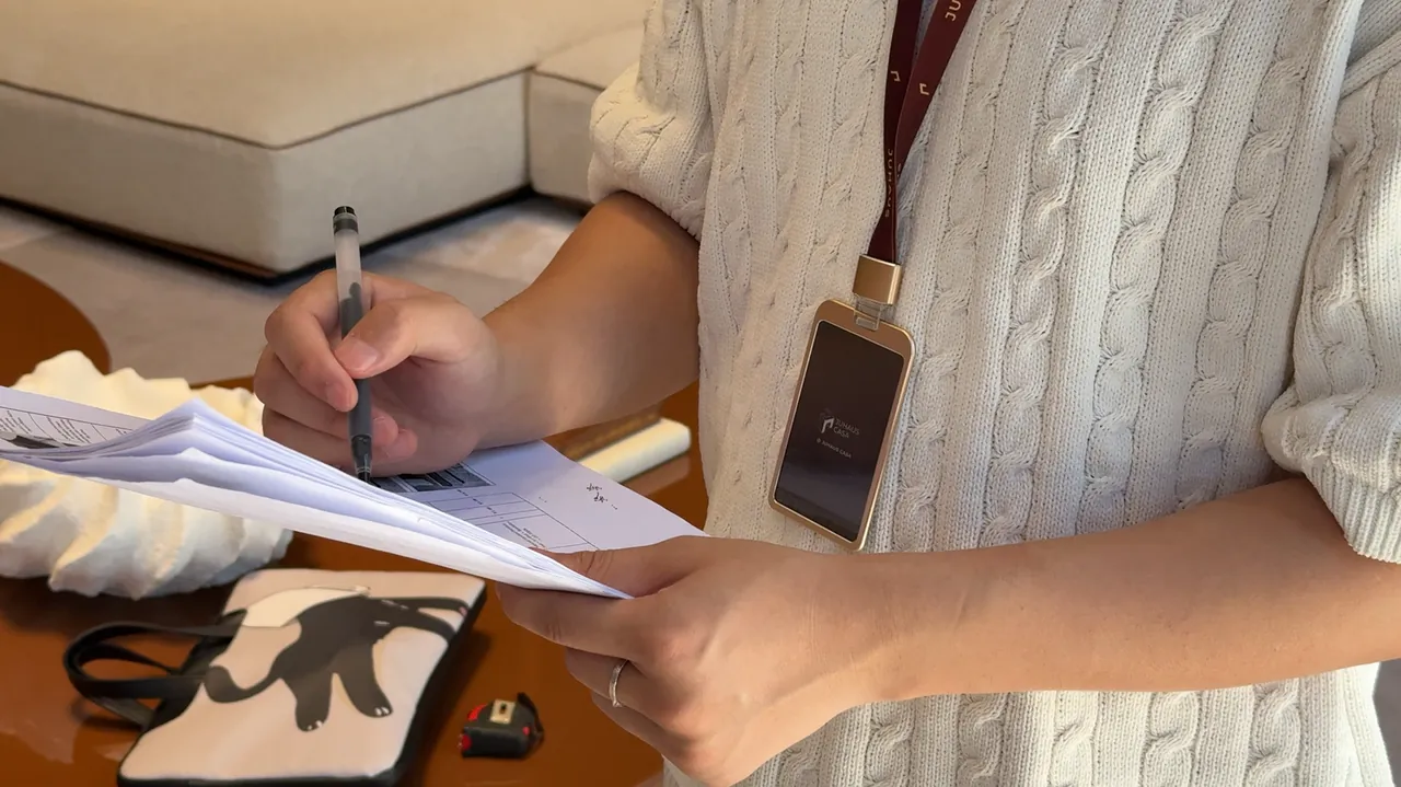 A person writes notes on a sheet while reviewing furniture in a showroom.